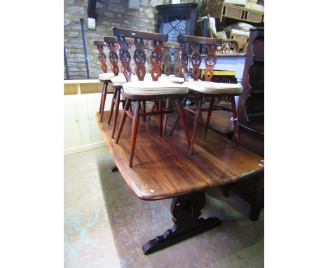 An Ercol dark stained elm refectory table raised on a pair of shaped end column supports united by a central pegged rail/stre