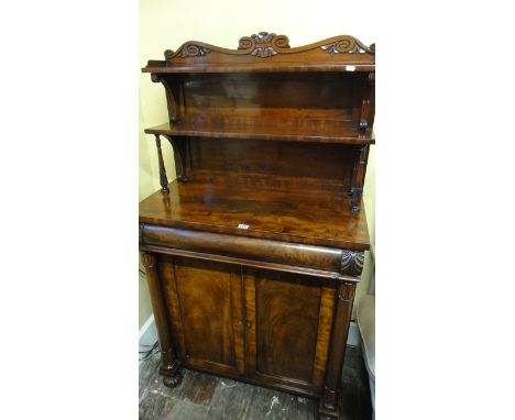 A small Regency mahogany chiffonier, the lower section enclosed by two panelled doors with well matched flame veneers within 