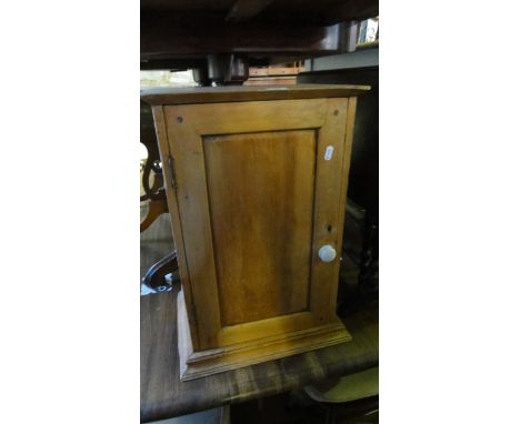 A small vintage stripped pine wall mounted bathroom cabinet enclosed by a rectangular panelled door, a pine occasional table 