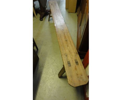 A vintage pine bench the long plank seat with rounded corners and through jointed splayed legs