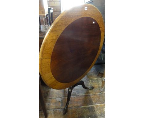 An oak and mahogany occasional table, the circular top 95 cm in diameter, raised on a turned pillar and tripod base with carv