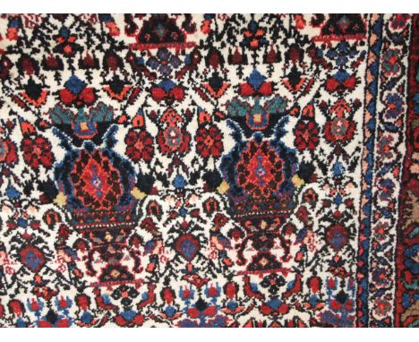 A eastern wool carpet, the cream field heavily decorated with symmetrical foliate and medallion decoration in shades of pink,