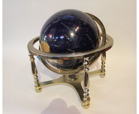 A large globe comprised of cut and polished semi-precious stone set upon a heavy free standing metalwork base and axis suppor