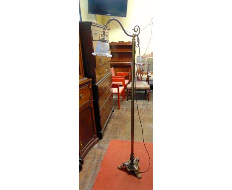 A brass swan neck standard lamp with ribbed moulded glass foliate shade, simple tubular stem shaped tricorn and paw feet