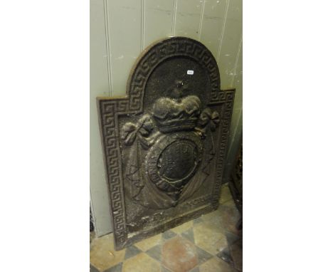 A heavy vintage cast iron fire back of stepped arched form with raised relief shield, coronet and tied ribbon detail within a