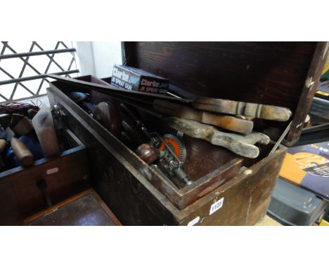 A vintage stained pine tool chest with hinged lid containing an assortment of mainly carpentry related hand tools to include 
