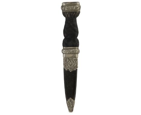 A Victorian white metal mounted sgian-dubh, 9.5cm blade with faceted back edge, black painted carved wooden grip decorated wi