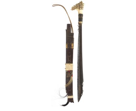 A 19th Century Dyak Head Hunters sword or Mandau, 49cm characteristic heavy set blade chiselled and turned to the underside o