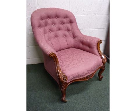 A Victorian balloon back, button upholstered arm chair with carved walnut continuous curves from arm to front, floral carved 