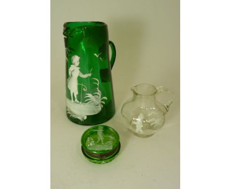 A small 19th Century clear glass jug with white painted Mary Gregory design 8cms high; a 19th Century green glass jug with wh