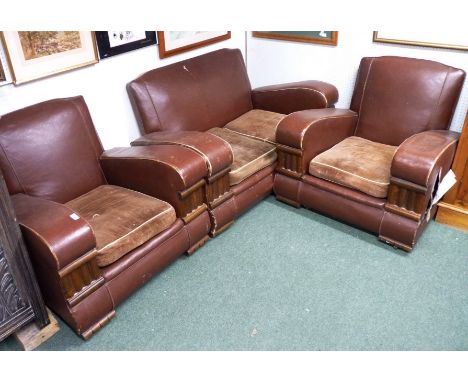 A Rexine covered Art Deco style three piece suite, comprising a two seater sofa and two armchairs, with moulded oak decoratio