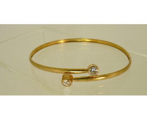 A 9ct gold flexible bangle of cross over design set with two cubic zirconias, in case, total weight 2.8g