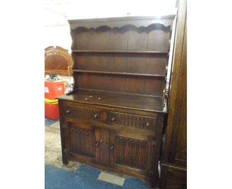 An Oak Linen Fold Two Drawer Dresser with Cupboard Base and Two Shelf Plate Rack, 120 cm Wide