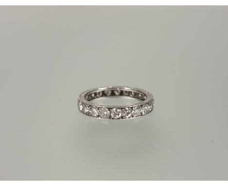 A diamond full hoop eternity ring, the round brilliant-cut stones (total c. 2.2ct), channel-set in an engraved white metal ba