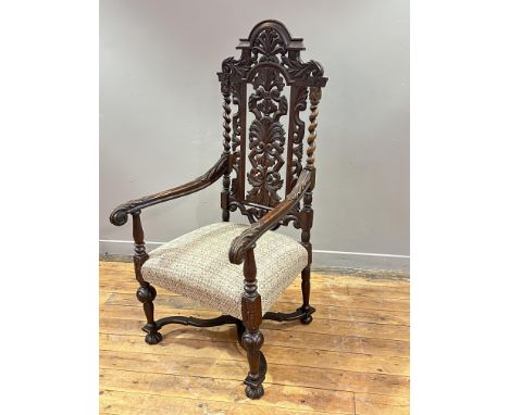 A carved oak Carolean style open armchair, 19th century, with carved splat back and acanthus scroll arms, flanking a stuffed-
