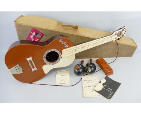 Elvis Presley, a 1950's novelty plastic guitar by Selco UK in brown and cream with portrait to the headstock 81cm long, in or