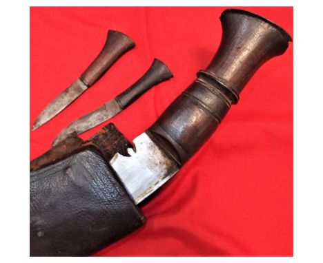 All wooden grip, with metal swollen kukri blade, showing issue stamp, in very good condition. Leather scabbard shows splits t