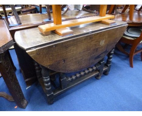 AN OAK GATE-LEG TABLE, with heavy bobbin turned supports (sd)