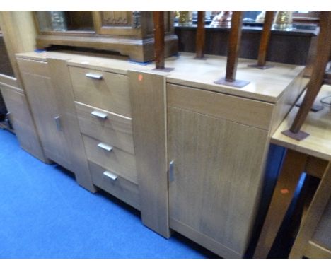 A MODERN LIGHT OAK SIDEBOARD, with four central drawers and two pull out sections revealing bottle holders (matching previous