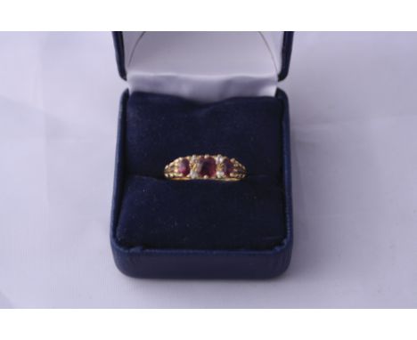 AN 18CT GOLD RUBY AND DIAMOND RING, with three cushion cut rubies and diamond accente, hallmarks for Birmingham, ring size O 