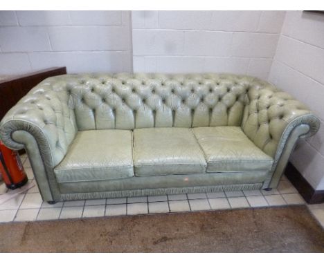 A PALE GREEN LEATHER THREE SEATER CHESTERFIELD SOFA, and a matching armchair (2)