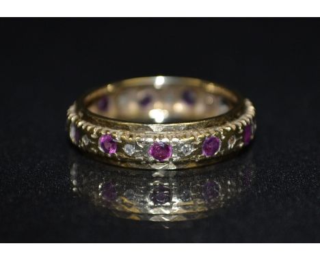 A diamond and ruby eternity ring, inset with an alternating band of eleven diamonds and eleven rubies (1 missing), 9ct gold s