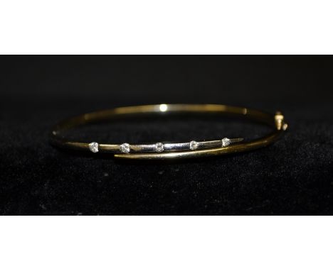 A contemporary diamond hinge bangle, linear set with five individually mounted round brilliant cut diamonds, to the white gol