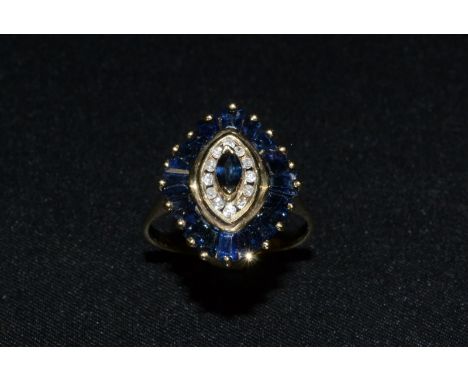 A 9ct gold navette shaped sapphire and diamond cluster ring, central oval deep blue sapphire surrounded by a band of twelve d