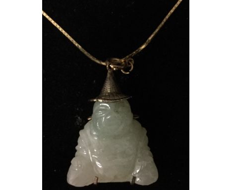 A carved jade Buddha pendant, seated laughing, wearing a yellow metal wide brimmed hat, and character script cage mount, stam