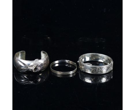 An engraved silver hinged bangle, a christening bangle, and a sterling silver bangle (3) 