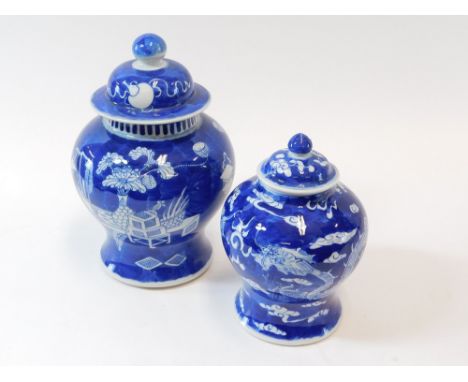 CHINESE BLUE & WHITE. Two Chinese blue & white jars with covers. The largest decorated with furniture & floral arrangements. 