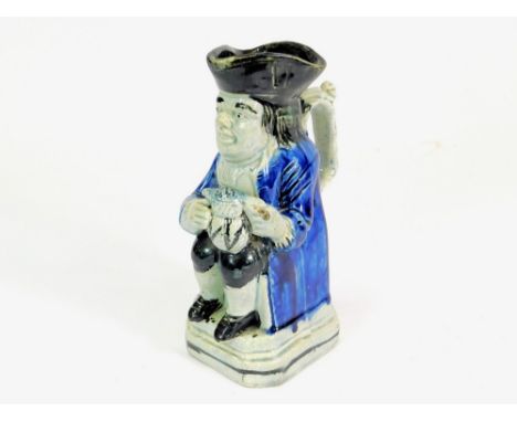 TOBY JUG. A 19th century pearl ware toby jug decorated in blue & black with ornate handle. Height 17cm.  Please note that all