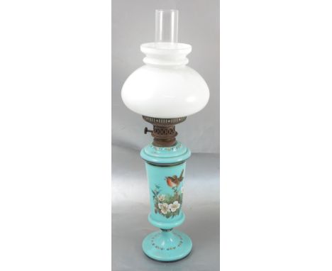 A silbers patent glass oil lamp, the blue glass body decorated with flowers, with milk glass shade