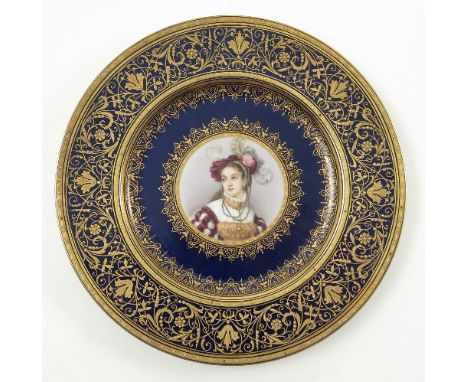 A late 19th/early 20th Viennese plate, decorated with a bust portrait of a young girl with feather and flowers in her hair, t