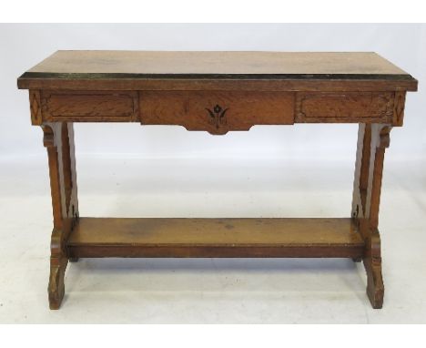 An oak Gothic revival side table, fitted with a frieze drawer, raised on pierced end supports, united by a shelf with line an