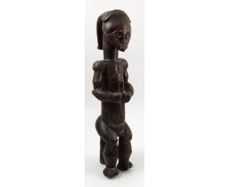 A Fang Gabon Reliquary figure, with heart shape face, triangular block nose and pursed lips, the long cylindrical body with a