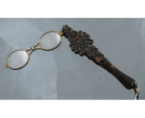 A tortoiseshell lorgnette, the pierced applied mount to a metal centre and glasses, length 15cms