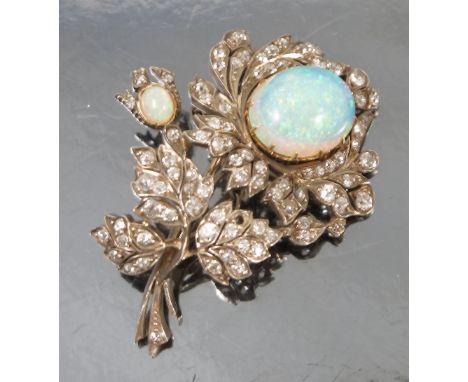 A late Victorian opal and diamond spray brooch, the principal opal approximately 15mm length, enclosed by diamond set leaves,