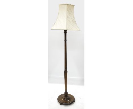 A mahogany standard lamp, having part fluted column, terminating in a circular base