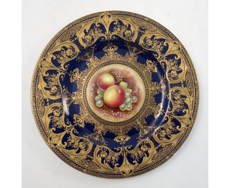 A Royal Worcester cabinet plate, hand painted with fruit to a mossy background by Leaman, to a deep dark blue and gilt border