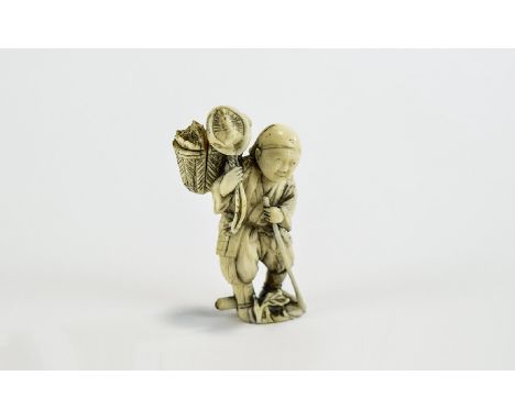 Ivory Figural Netsuke, showing a man walking along with a staff, carrying a creature in a basket on his shoulder; the man wea