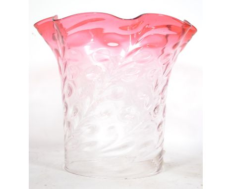 An early 20th century part cranberry and clear glass oil lamp shade with scalloped edgings