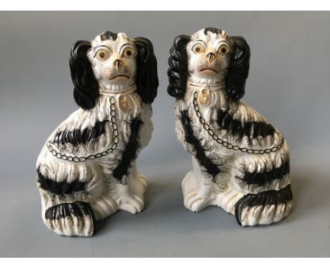A pair of Staffordshire black and white spaniels.