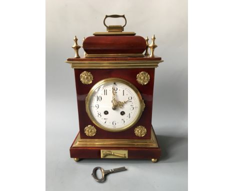 A mock tortoiseshell mantel clock with brass details. Height 35cm.
