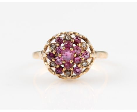 A 9ct yellow gold ruby and diamond tiered cluster ring, set with two tiers of round cut rubies, the third tier with alternate