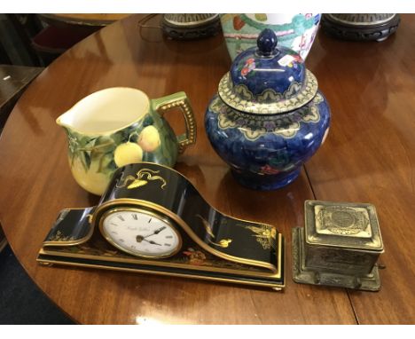 A decorative lidded China vase, decorative jug, metal cigarette box and a modern black lacquered mantel clock.