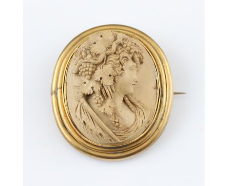 A large lava cameo brooch, the oval cameo depicting ladies portrait in profile with grape vine in hair, surrounded by an unma