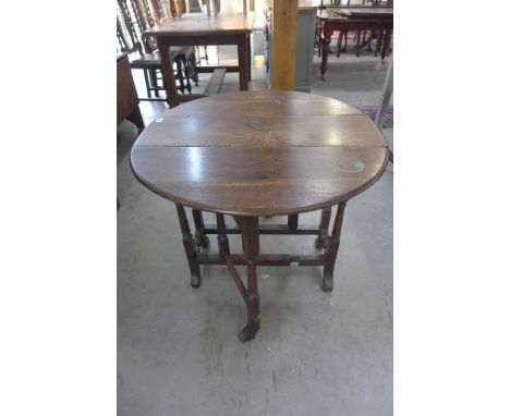 An 18th century Dutch oak drop leaf table with gate leg action on turned trestle supports - 68cm x 80cm x 85cm