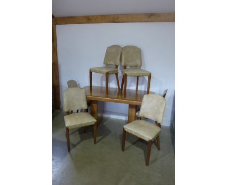 An Art Deco walnut dining suite comprising table having rectangular top with canted corners upon twin pedestals with six dini