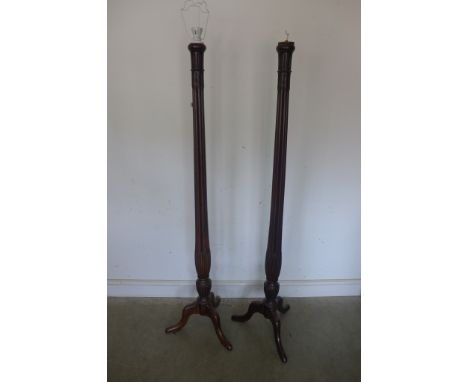 A pair of early 20th century mahogany tourcheres converted to electricity with lotus leaf carving, fluted supports on tripod 